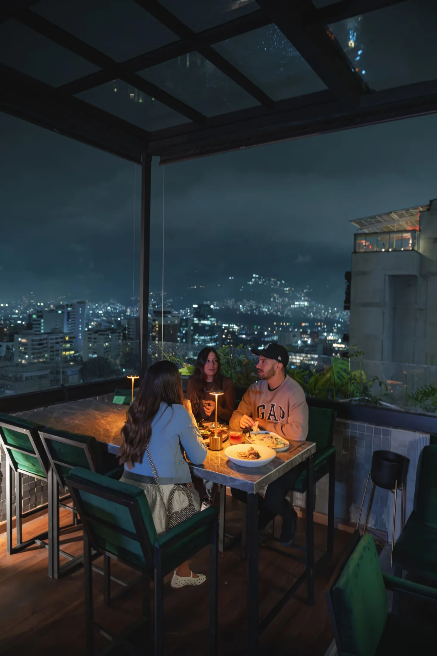 Guests at Hunters’ Martini rooftop overlooking Medellín at night